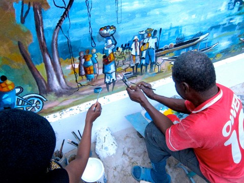 24 augustus 2012 › En étroite collaboration avec son père, Rhode Makoumbou réalise une fresque murale intitulée «Le village de pêcheurs».