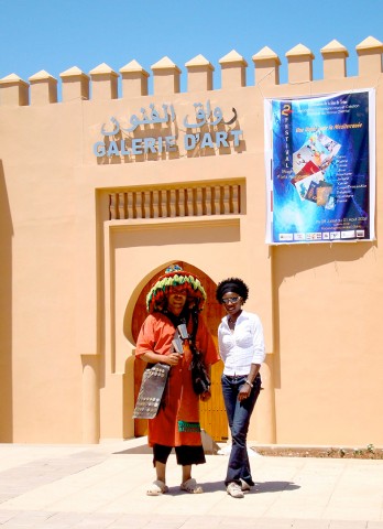 Rhode Makoumbou avec un vendeur d'eau à l'entrée de la salle d'exposition «Galerie d'Art»