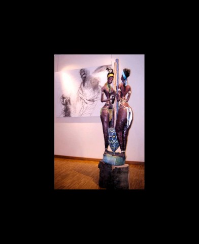 25 januari 2007 › «Les pileuses», sculpture de Rhode Makoumbou exposée à la Maison du Peuple. En arrière-plan : un dessin du peintre Roger Somville.