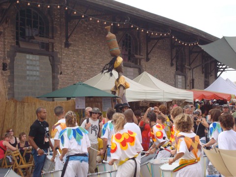 27 juin 2009 › Performance d'une fanfare au Festival Couleur Café. En arrière-plan : la sculpture de Rhode Makoumbou «La porteuse d'eau».