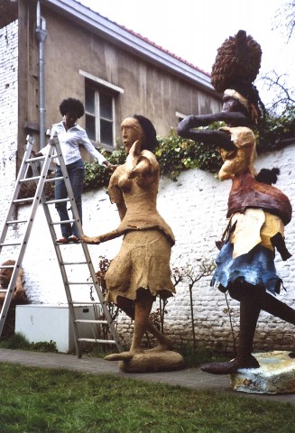 Rhode Makoumbou en haut d'une échelle afin de travailler sur une sculpture monumentale