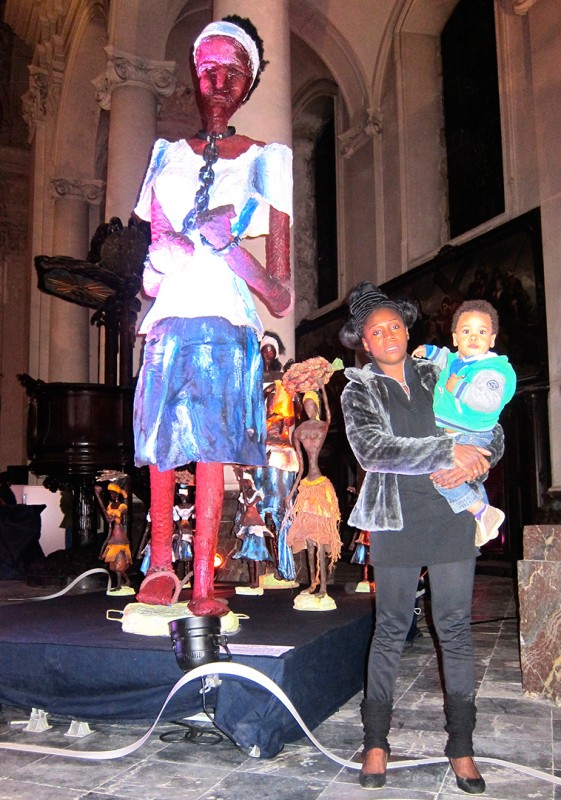 18 octobre 2013 › Rhode Makoumbou avec son fils Quentin, à côté de sa sculpture «Liberté ! Colère contre l'esclavagisme et la colonisation».