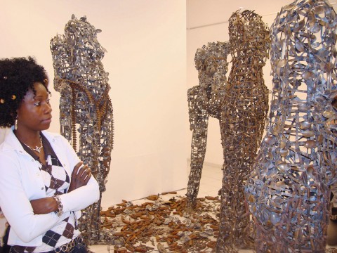 Rhode Makoumbou contemplant les sculptures de l'artiste congolais Freddy Tsimba