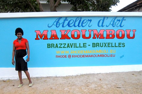 Rhode Makoumbou devant le mur d'enceinte de sa maison
