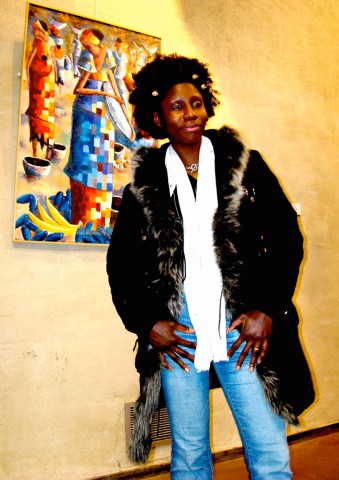 Rhode Makoumbou devant une de ses peintures