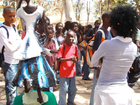 13 mei 2008 › Visite de lycéen(ne)s à la Biennale Dak'Art 2008. En avant-plan, de dos : Rhode Makoumbou à côté de sa sculpture «Le mponzi».